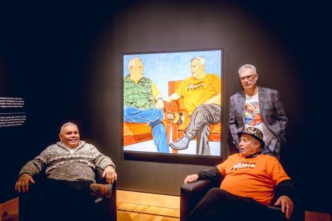 three men chatting in an art exhibtion